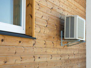 Air conditioner condenser on the wooden wall of boards.