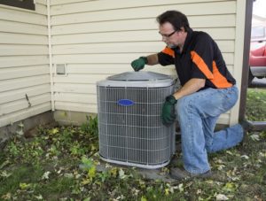 Repairman tightening fan shroud on outside air conditioning unit