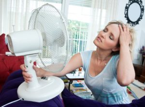 woman cooling herself with fan