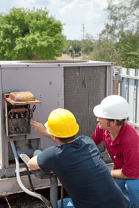 commercial heating and air conditioning repair technicians inspecting a unit