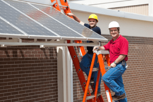 Contractors maintaining solar panel on building