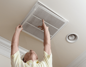 Man opening ac air filter in ceiling