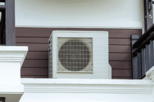 AC unit attached to a dark brown wooden structure of building