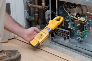 Technician holding tool while inspecting the back of AC unit