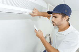 Technician inspecting unit while holding ac control