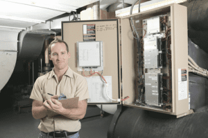 Technician holding report and pen while standing in front of equipment 