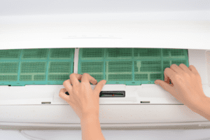 Hand placing filter inside AC unit