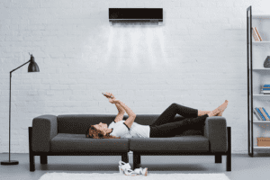 woman relaxing on sofa with ac unit above head 