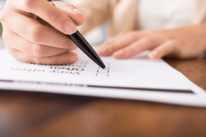 Caucasian Hands holding black pen and checking list on white paper