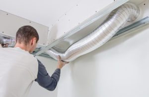 Man setting up ventilation system indoors