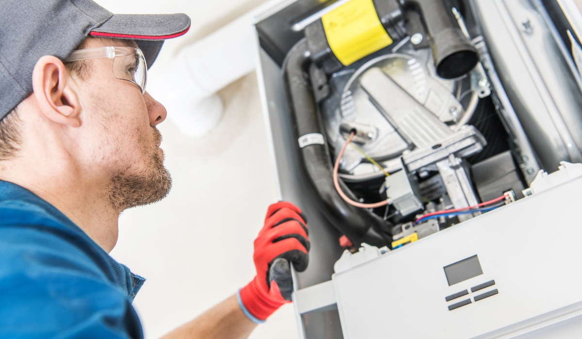 HVAC Tech Looking At The Inside Of A Newer Furnace During install