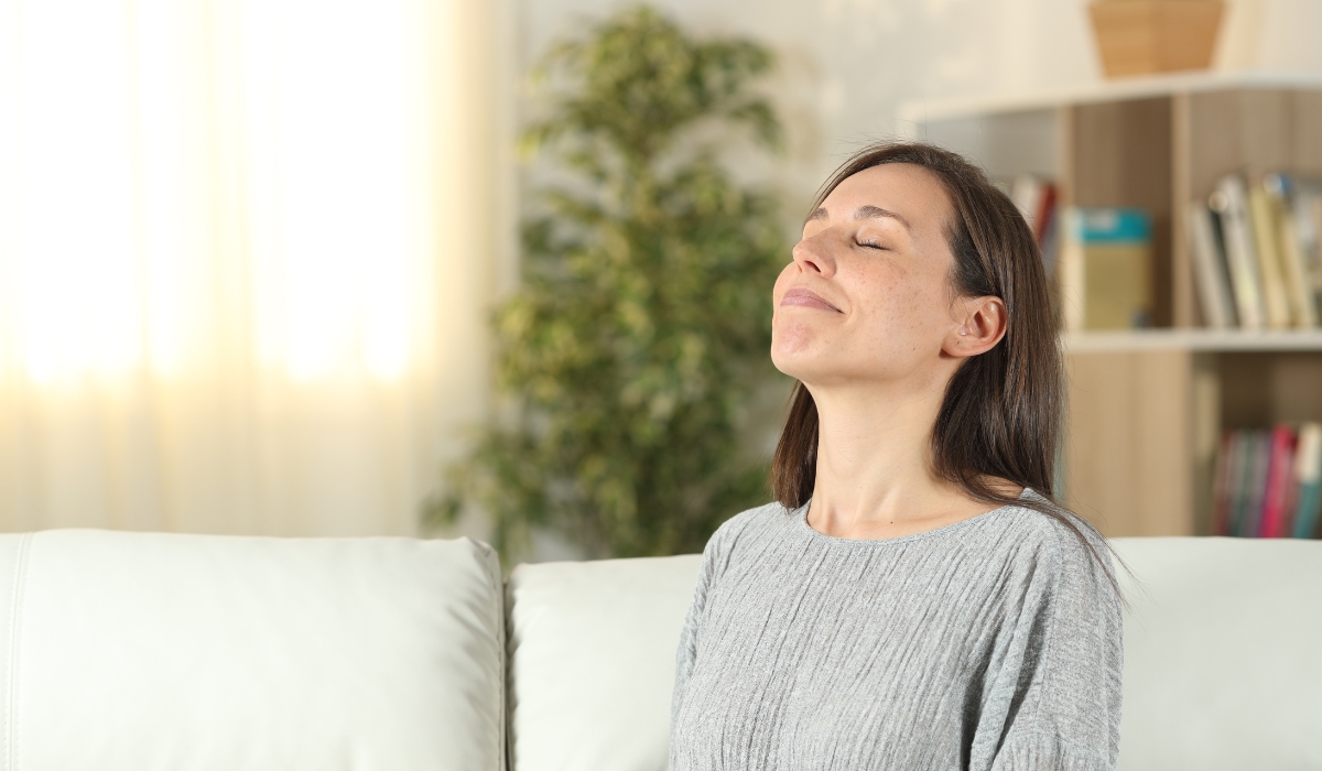 Woman Taking A Deep Breathe Of Clean Air In Her Home