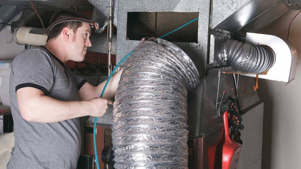 A ventilation cleaner man at work with tool